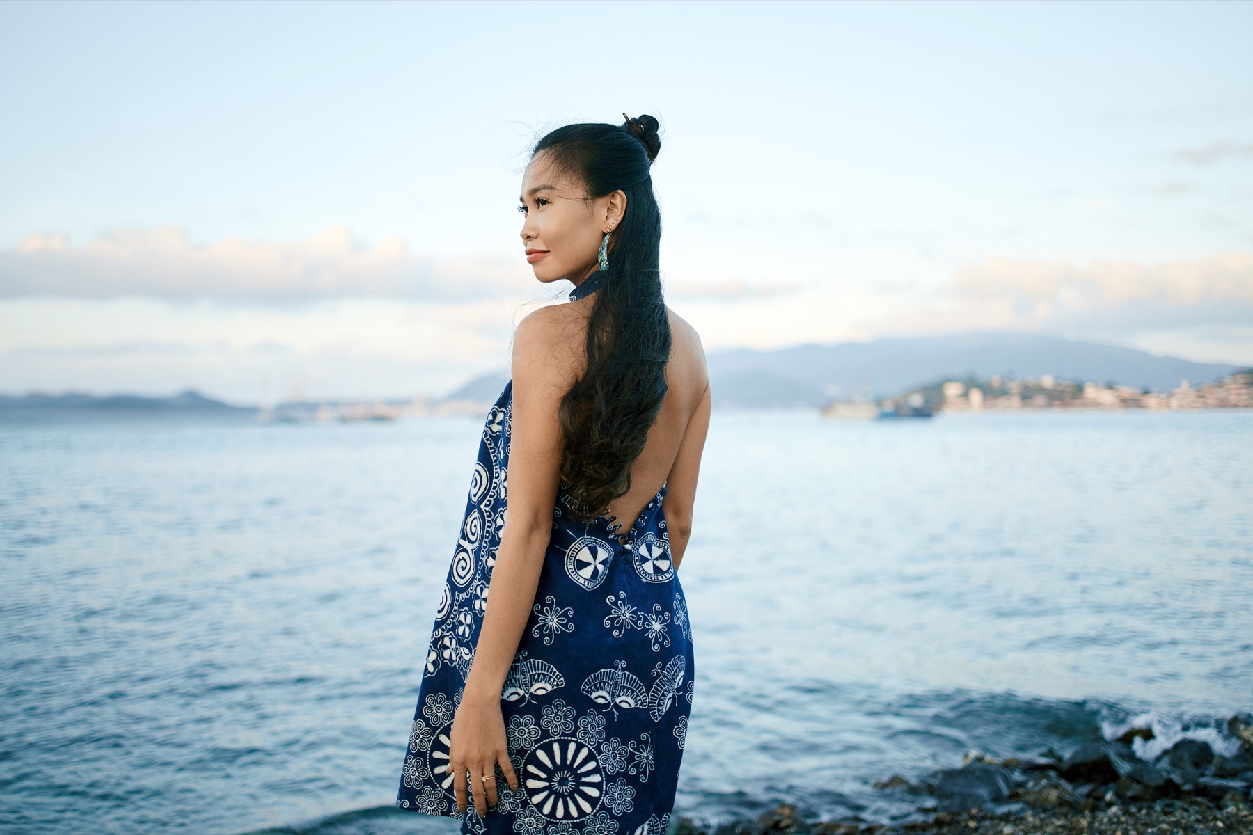 Woman wearing a blue-and-white open-back SexyBack dress beside the sea